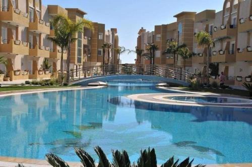a large swimming pool in front of some apartment buildings at Résidence les dunes in Hammam Sousse