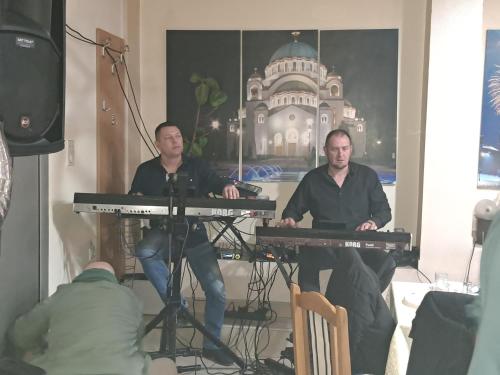 two men sitting at a keyboard in a room at HOTEL Crystal Lights in Pirot