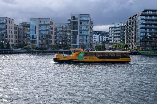 a yellow boat in the water in a city at Apartment in Copenhagen with water view in Copenhagen