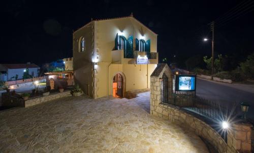 a large yellow building with a door at night at Skandalis Apartments with pool in Chorafakia