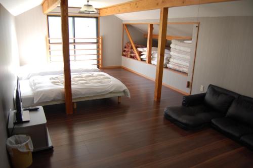 a bedroom with a bed and a couch in a room at Chalet 別邸しろうま in Hakuba