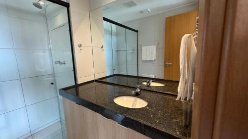 a bathroom with a sink and a glass shower at Studio Confortável em Muro Alto in Ipojuca