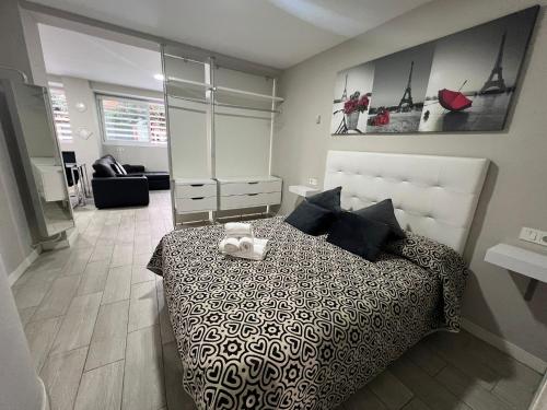 a bedroom with a bed with a black and white bedspread at El Encanto Andaluz 1 in Córdoba