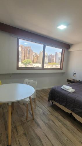 a room with a bed and a table and a window at MONOAMBIENTE VILAUT Temporario in Córdoba