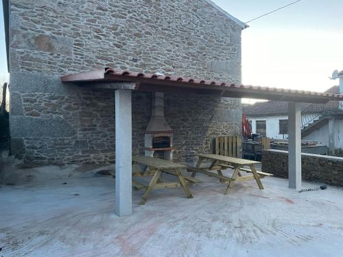 a picnic table and a fireplace on a patio at Casa de Maçaneira in Miranda do Douro