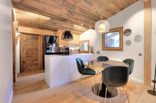une cuisine et une salle à manger avec une table et des chaises dans l'établissement SANTA MARIA MEGEVE proche village, à Megève