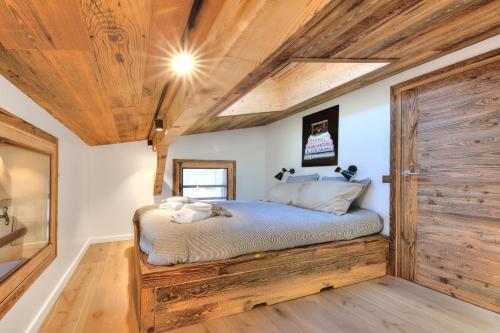 - une chambre avec un lit et une porte en bois dans l'établissement SANTA MARIA MEGEVE proche village, à Megève