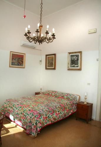 a bedroom with a bed and a chandelier at B&B Villa Pallante in Bari