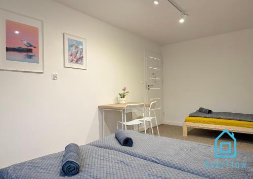 グダニスクにあるSandcastle Room - 1 km to Baltic Sea & 15 Minutes to Gdańsk Old Townのベッドとテーブルと机のある寝室