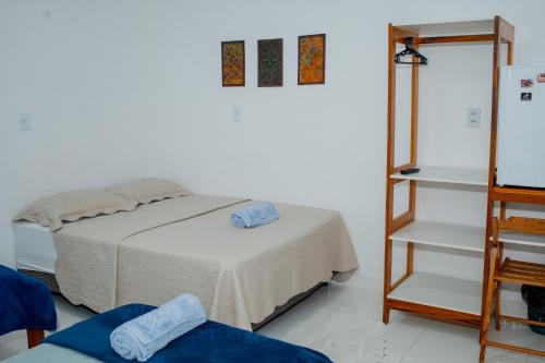 a white room with a bed and a mirror at Pousada Muiraquitã Parintins in Parintins