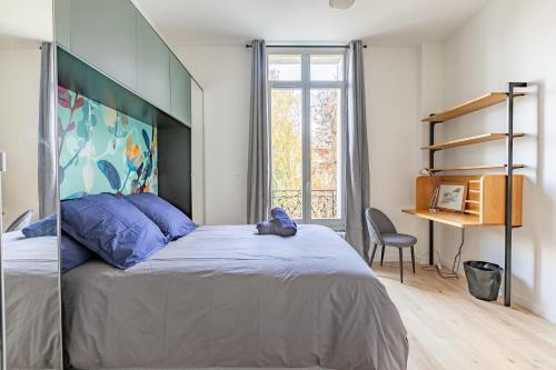une chambre avec un grand lit et un bureau dans l'établissement Villa Stella, à Compiègne