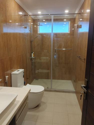 a bathroom with a toilet and a glass shower at Royal Feather in Tirunelveli East