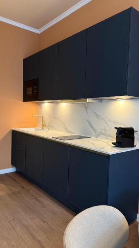 a blue kitchen with a counter and a sink at Atrium Apartments Aachen in Aachen