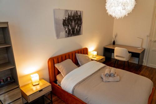 a bedroom with a bed with a pair of shoes on it at Charme et confort au coeur d'Angers in Angers