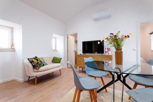 a living room with a glass table and chairs at Casa da Boneca in Batalha