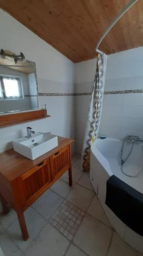 une salle de bain avec un lavabo, un lit et un miroir dans l'établissement Charmante maison de pays dans le centre de St Denis D'Oléron, à Saint-Denis-dʼOléron
