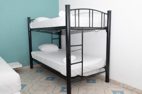a black bunk bed with white pillows on it at Casa Colonial Tulum in Tulum