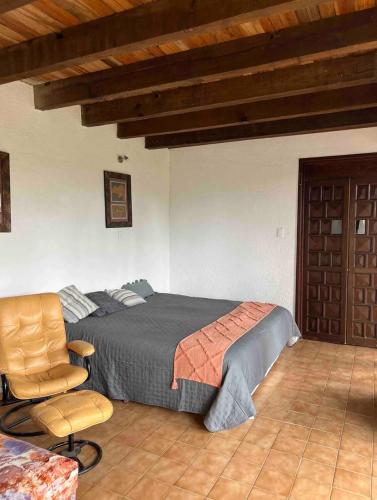 a bedroom with a bed and a chair at Casa Massaryk with Incredible Mountain Views in Santa Ana