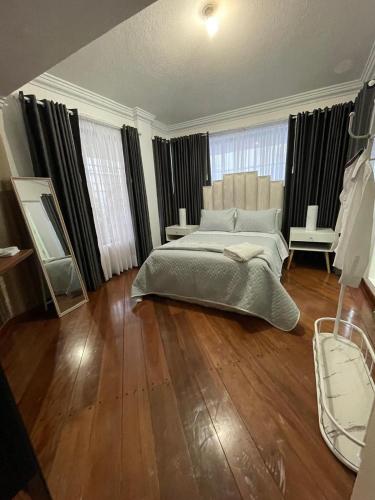 sypialnia z dużym łóżkiem i drewnianą podłogą w obiekcie Lili’s room w mieście Quito