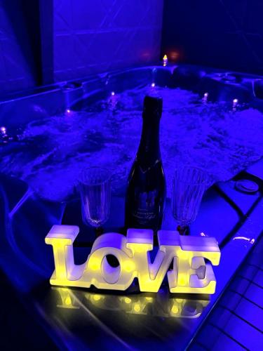 a bottle of beer and some glasses in a tub at Love Room Spa - Sauna - Hammam in Domérat