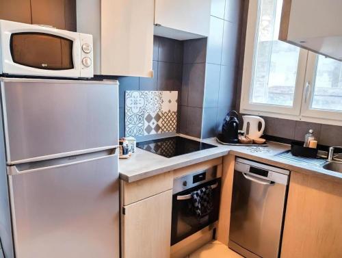 a kitchen with a refrigerator and a microwave at Le Fleury appartement moderne 2 chambres, à côté du salon du Bourget in Le Blanc-Mesnil