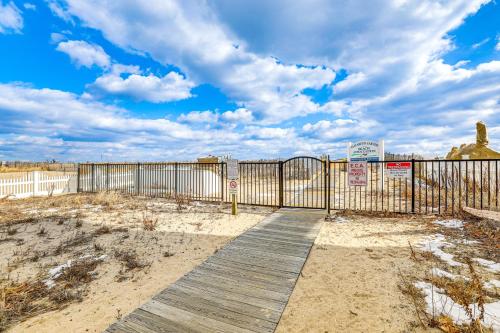 a wooden boardwalk with a gate on a beach at 1 Mi to Jenkinsons Boardwalk Family Gem with Grill in Point Pleasant Beach