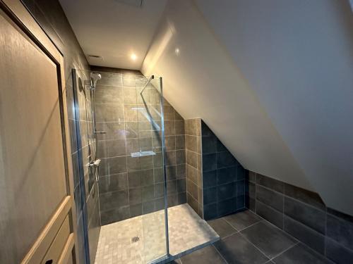 une salle de bain avec une douche avec une porte vitrée dans l'établissement Gite de caractère entièrement restauré, à Saint-Pierre-du-Val