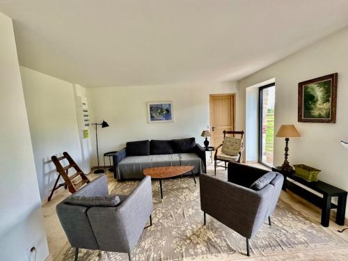 un salon avec un canapé, des chaises et une table dans l'établissement Gite de caractère entièrement restauré, à Saint-Pierre-du-Val