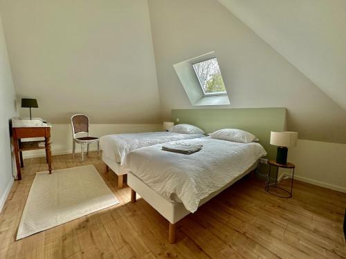 une chambre avec un lit, une table et une fenêtre dans l'établissement Gite de caractère entièrement restauré, à Saint-Pierre-du-Val