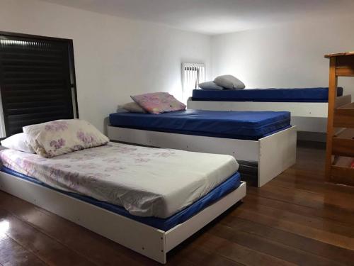 two beds in a room with blue and white at Apartamento no Centro de Mongaguá in Mongaguá