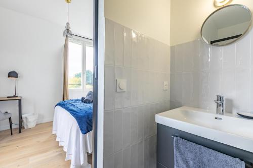 une salle de bain avec un lavabo et un miroir dans l'établissement Villa Stella, à Compiègne