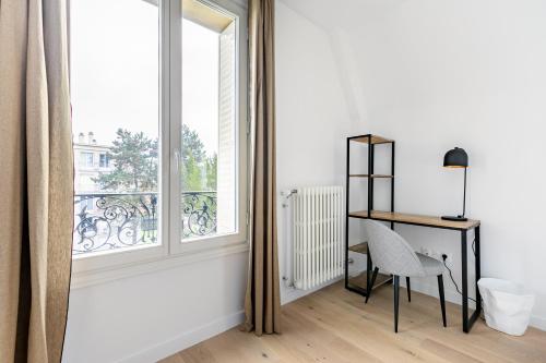 Cette chambre blanche dispose d'un bureau et d'une fenêtre. dans l'établissement Villa Stella, à Compiègne