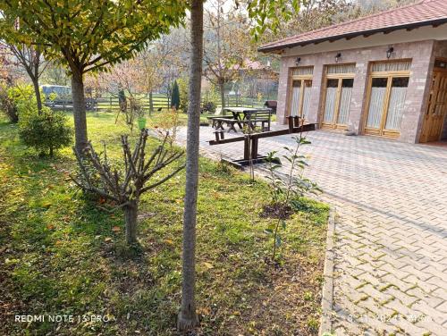 a patio with a picnic table and a building at Apartman Quince Gradac in Valjevo