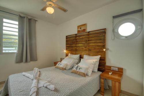 sypialnia z dużym łóżkiem z drewnianym zagłówkiem w obiekcie Mqsl25 w mieście Sainte-Luce