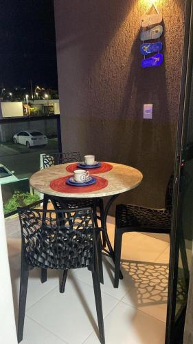 a table with two chairs and a cup of coffee on it at Makia Beach experience Flat 115 A in Porto De Galinhas