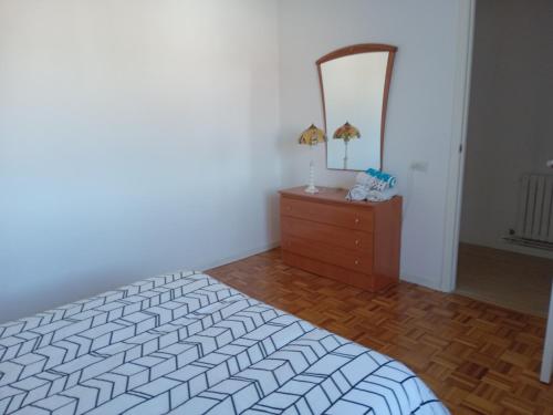 a bedroom with a bed and a dresser and a mirror at Paseo de noia in Noya