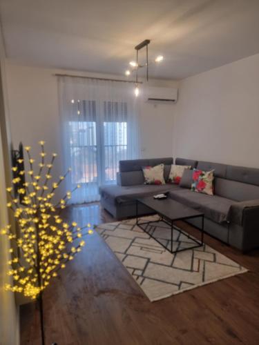 a living room with a couch and a christmas tree at M&E Prishtina apartment in Prishtinë