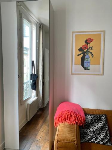 - un salon avec un canapé et un vase de fleurs dans l'établissement Paris Montmartre sacré coeur, à Paris