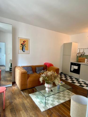 un salon avec un canapé et une table en verre dans l'établissement Paris Montmartre sacré coeur, à Paris