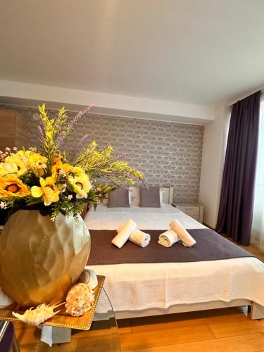 a bedroom with a bed with a vase of flowers at Lira Beach Studio in Mamaia