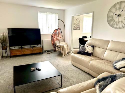 a living room with a couch and a flat screen tv at Great location very spacious. Sea and castle view in Marazion