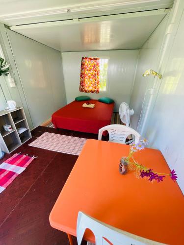 a small room with a table and a bed at Pension Fare Hiro Moorea in Vaianae
