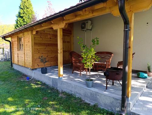 a wooden pergola with chairs and a patio at Apartman Quince Gradac in Valjevo