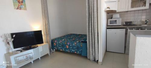 Cette petite chambre comprend un lit et une télévision. dans l'établissement studio proche gare et ville, à Antibes