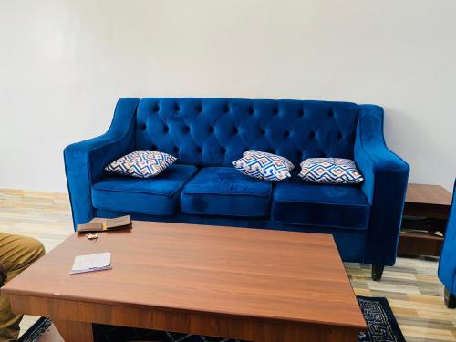 a blue couch in a living room with a coffee table at SWB Appartement in Kigali