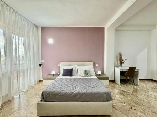 une chambre avec un grand lit et un bureau dans l'établissement La Residenza, appartamento centrale e moderno - Marea Stays Collection, à Nardò