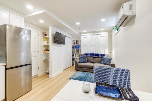 a kitchen and living room with a couch and a refrigerator at 7 Mi to National Mall Bright DC Studio! in Washington, D.C.