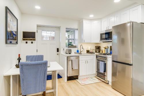 a kitchen with white cabinets and a stainless steel refrigerator at 7 Mi to National Mall Bright DC Studio! in Washington, D.C.