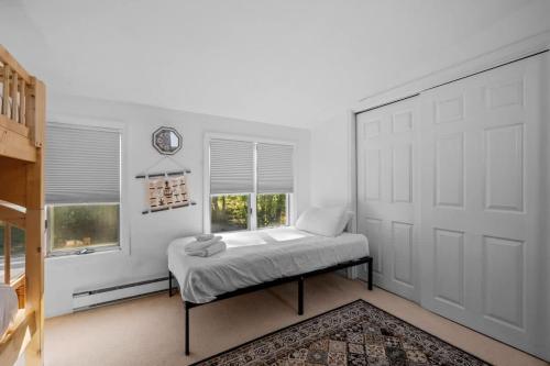 ein Schlafzimmer mit einem Bett und einer weißen Tür in der Unterkunft Lake Home with Private Beach and Hot Tub in Ossipee