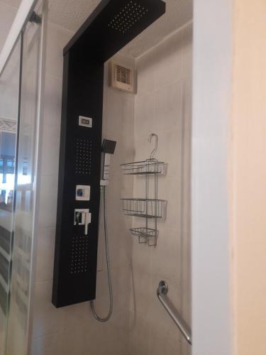 La salle de bains est pourvue d'une douche et d'un téléphone mural. dans l'établissement VILLAGE NATURISTE CAP D AGDE HELIOPOLIS D la maison d'andréas, au Cap d'Agde